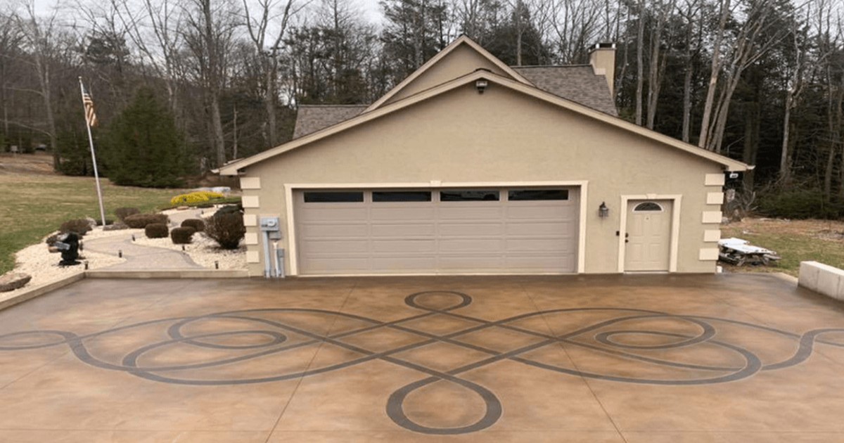 Large residential concrete driveway engraved with sweeping circular patterns